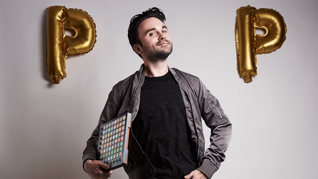 Dr. Pop mit einem Musikcontroller zwischen zwei goldenen Luftballons